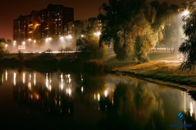 Опори вуличного освітлення вздовж міської водойми