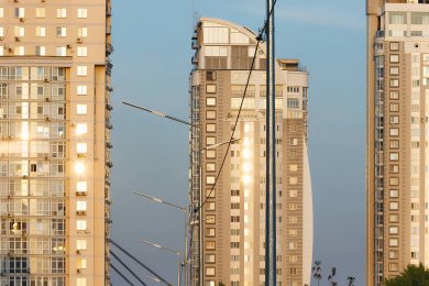 Опори вуличного освітлення в місті на фоні високі будинки