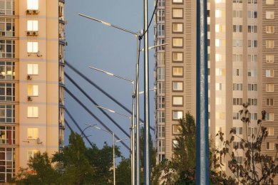 Опори вуличного освітлення в місті на фоні багатоповерхівок