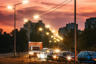 Опори вуличного освітлення в місті біля дороги на фоні вечірнього неба