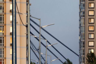 Опори вуличного освітлення біля високих будинків вид зліва