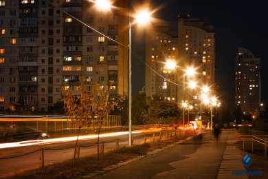 Опори вуличного освітлення на вулиці міста біля високих будинків