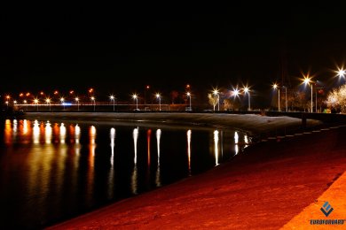 Опори вуличного освітлення на набережній в темряві