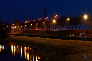 Опори вуличного освітлення набережної в сутінках