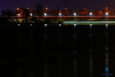 Опоры уличного освещения вдоль набережной в темноте