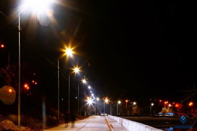 Опоры уличного освещения вдоль набережной, освещение в темноте