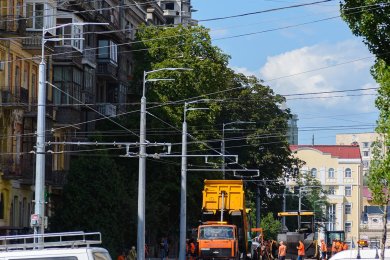 Опоры контактной сети вдоль городской дороги рядом со зданиями