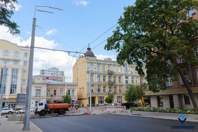 Опоры контактной сети рядом с дорогой и городскими зданиями