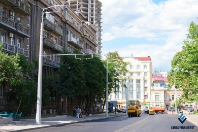 Опоры контактной сети на тротуаре возле городской дороги