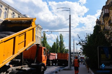 Опоры контактной сети на тротуаре вдоль городской дороги